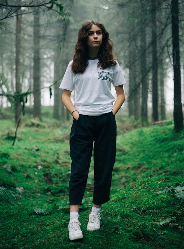 Hand holding black machined steel mechanical pencil with brass tip and top.